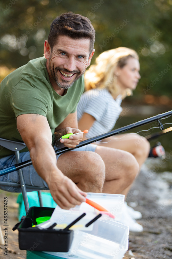 young couple is enjoying fishing on sunny day