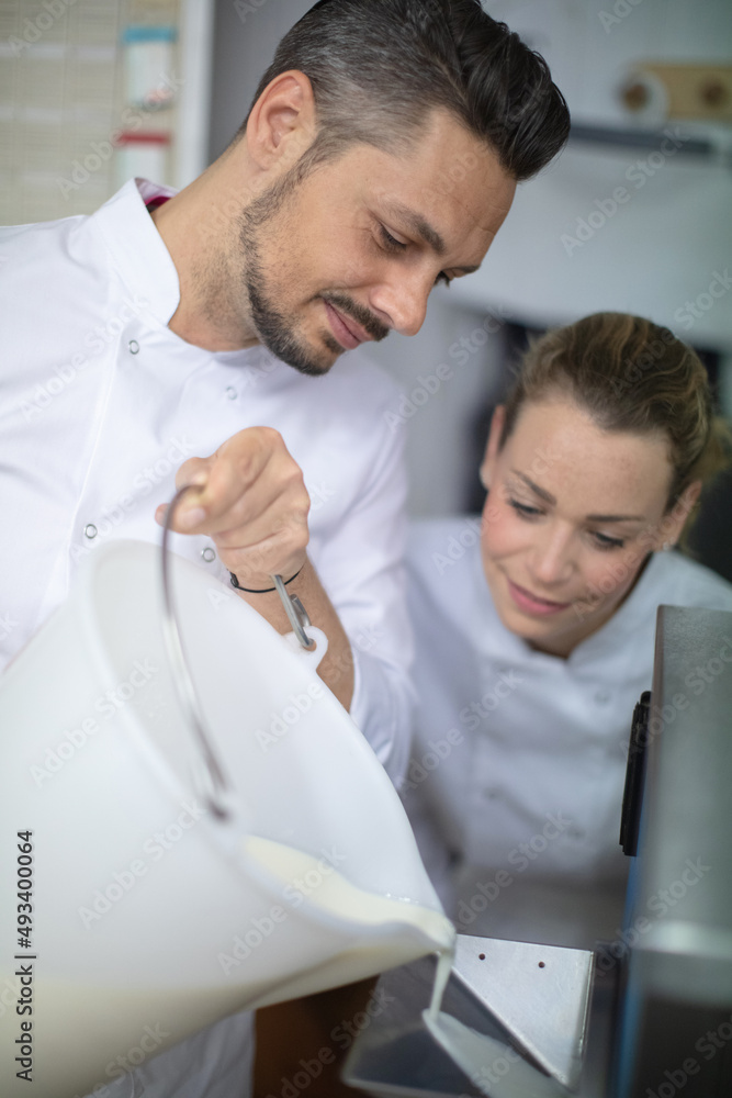Fototapeta premium chef pouring liquid into indutrial machine