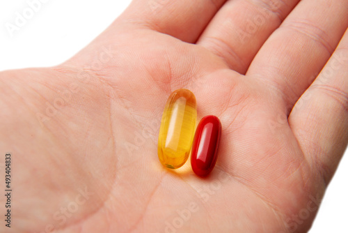 Two medicines capsules tablets are in the man's hand. The concept of decision-making medicine.
