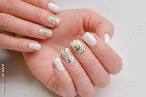 Beautiful female hand with spring manicure on white background