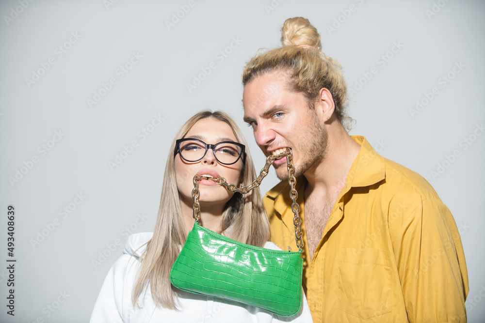 Couple holds fashion handbag in mouth. Ladies handbag. Lovers and valentines day. Couple holds fashion handbag in mouth. Ladies handbag. Lovers and valentines day.