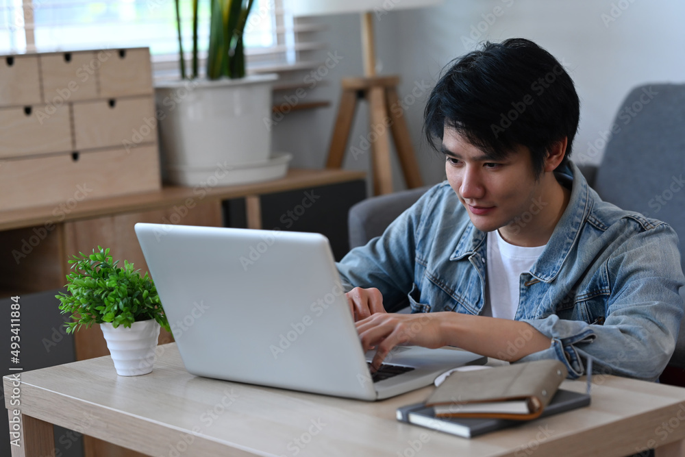 Man using internet banking service, searching information on laptop computer in living room. Man using internet banking service, searching information on laptop computer in living room.