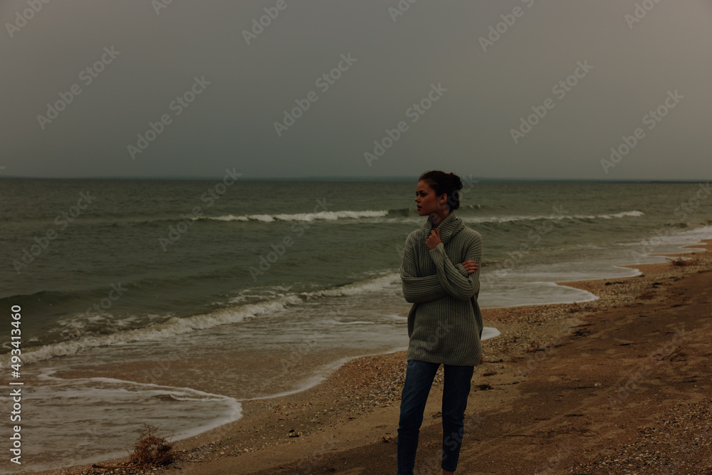woman red hair in a sweater by the ocean Happy female relaxing woman red hair in a sweater by the ocean Happy female relaxing
