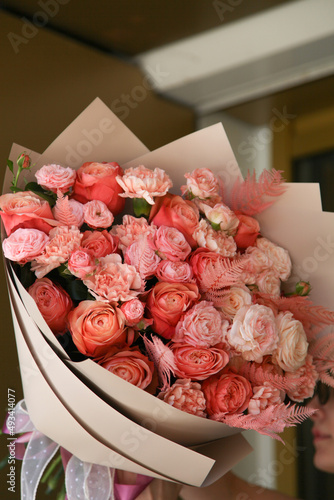 a bouquet of peach roses in the hands of a girl