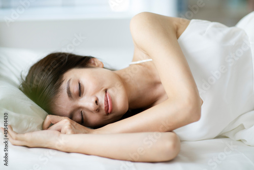 ベッドで気持ちよさそうに寝る女性 photo