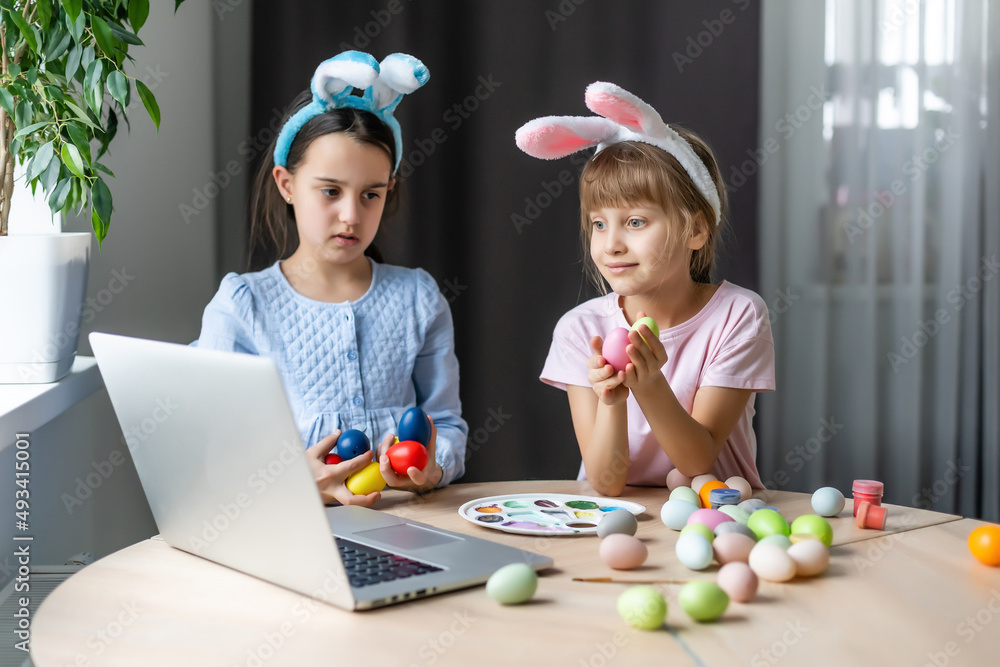 little girls for easter paint eggs, record lessons on web camera with laptop little girls for easter paint eggs, record lessons on web camera with laptop