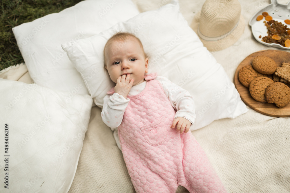 little girl resting on a blanket in the park