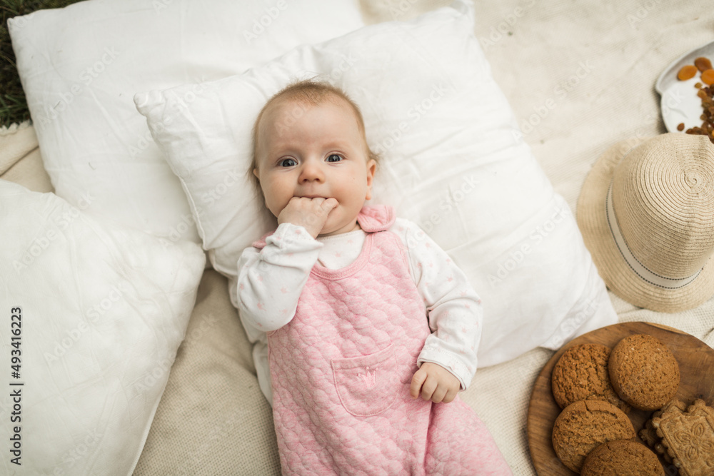 little girl resting on a blanket in the park