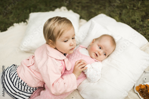 two little sisters play on the picnic