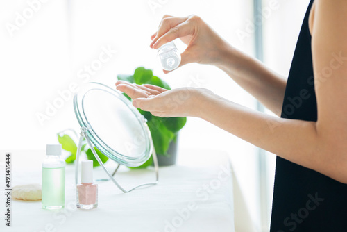 化粧水を手に垂らす女性の手元 photo