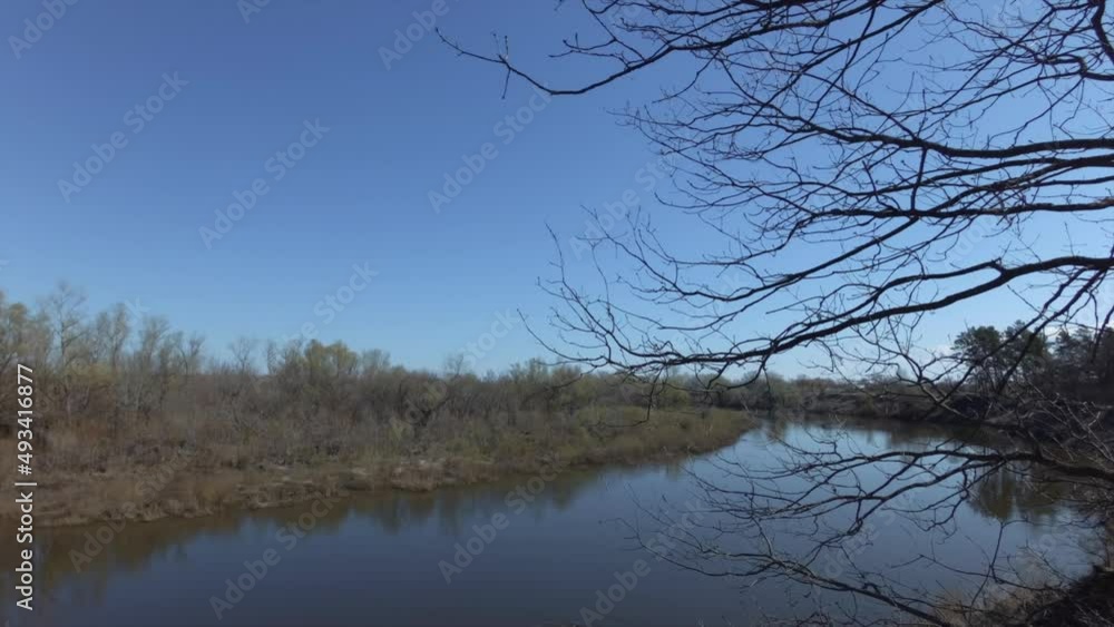 Russian nature. Panorama of river in early spring. Deciduous forest and shrubbery on shore of pond. Calmness and tranquility concept. Russian nature. Panorama of river in early spring. Deciduous forest and shrubbery on shore of pond. Calmness and tranquility concept.