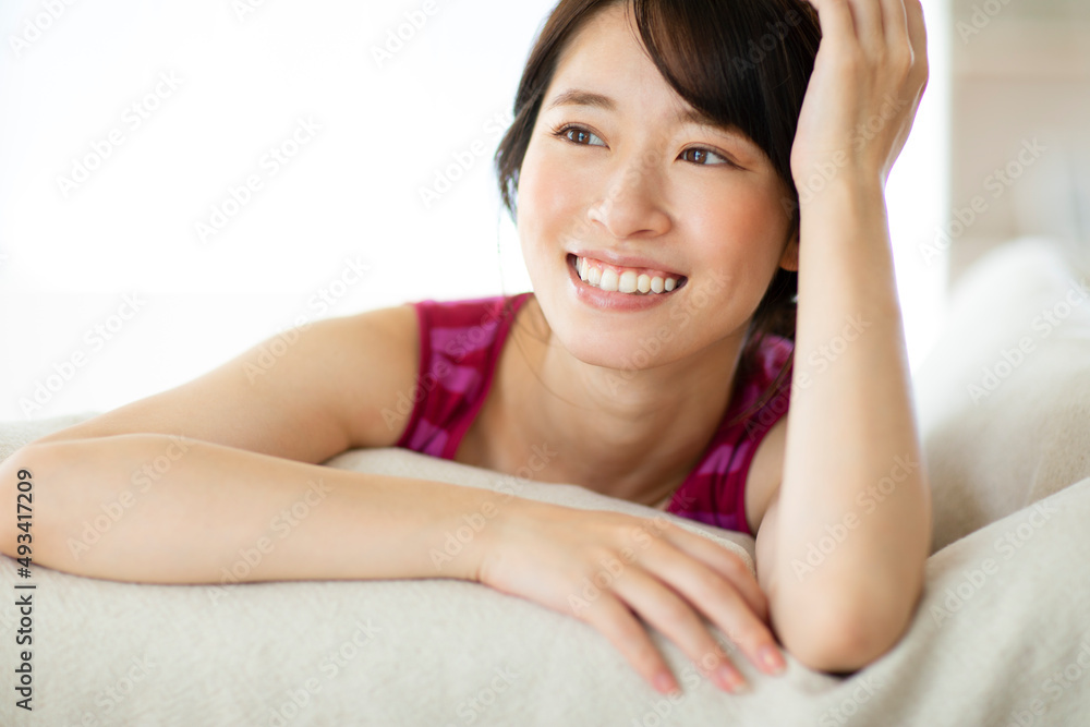 ベッドに横たわる笑顔の女性 ベッドに横たわる笑顔の女性