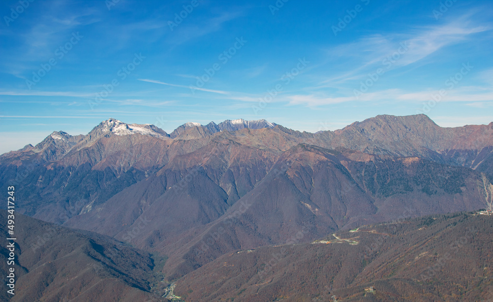 Landscapes in the mountains near Sochi in Russia. High mountain peaks and valleys in the rays of the sun in autumn.
