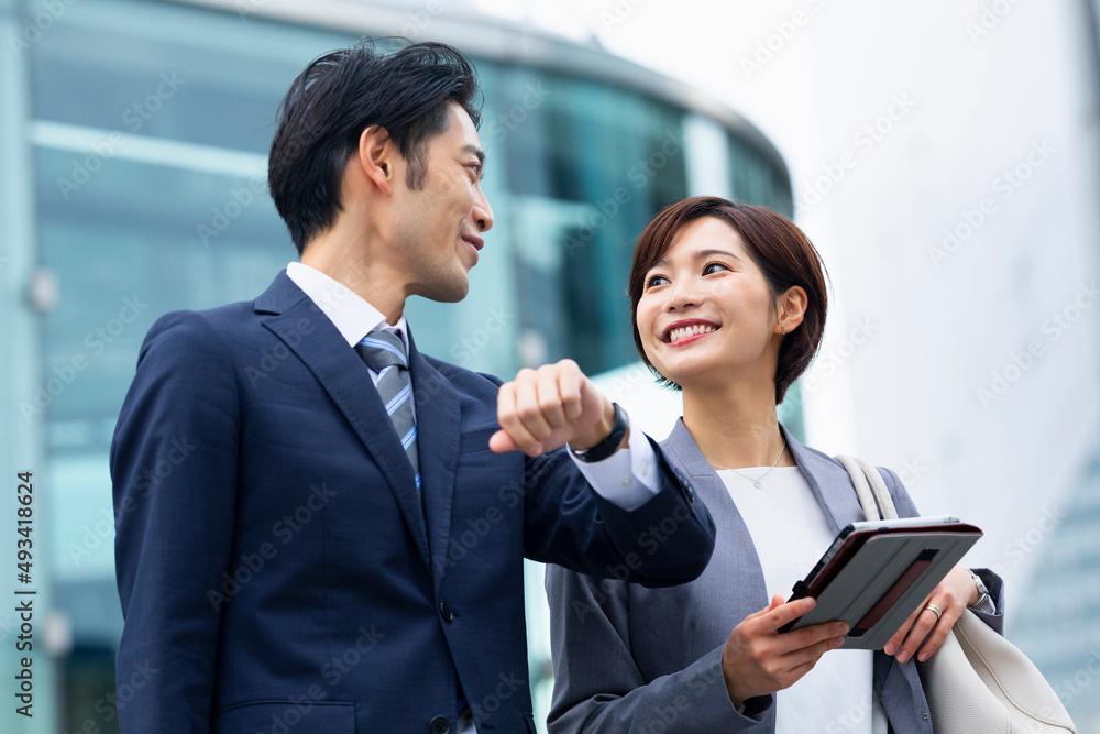 会話しながら歩くビジネススーツの男女