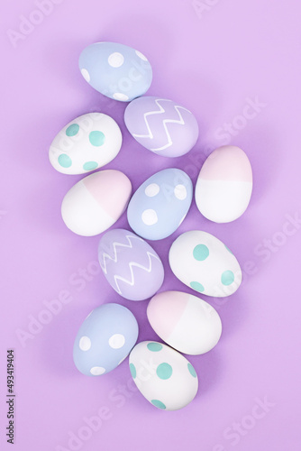 Top view of group of pastel colored easter eggs on violet background