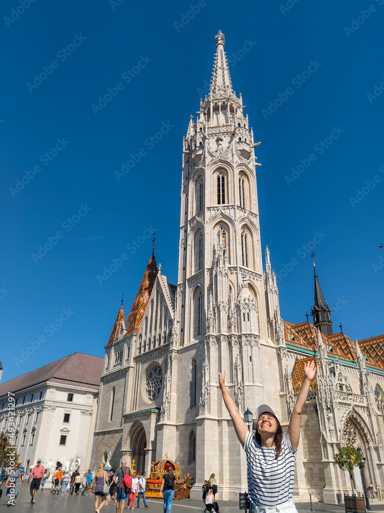 happy woman traveler looking at beautiful church in the center of Budapest