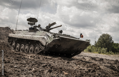 Soviet infantry fighting amphibious tracked vehicle BMP-1 in action at the battlefield. photo