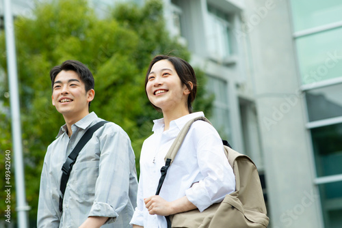 笑顔でキャンバスを歩く男子学生と女子学生
