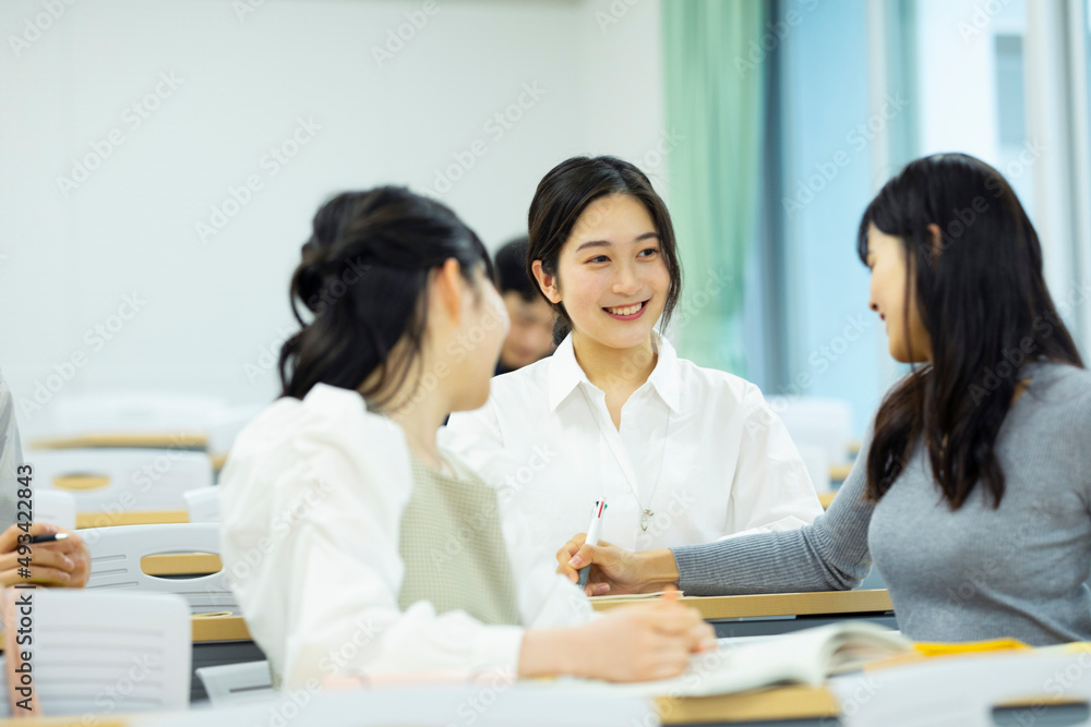 教室で談笑する大学生たち 教室で談笑する大学生たち