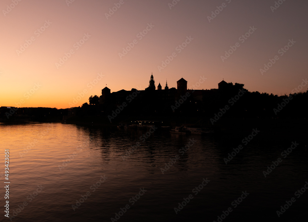 Silhouette of the Wawel Hill Kraków with Royal Castle. Located on the bank of Vistula River (Wisła) in Old Town district. UNESCO World Heritage Site in Krakow, Poland. Beautiful sunset over Kraków.
