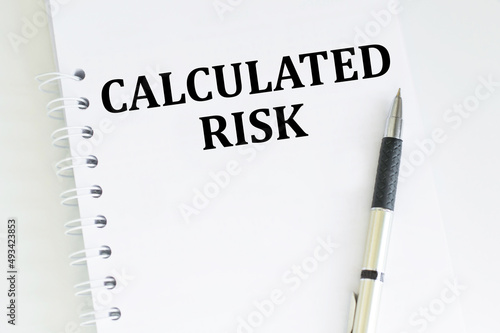 CALCULATED RISK text written on notebook on the a table