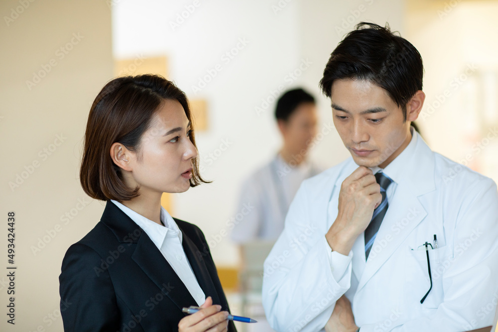 打ち合わせをするビジネスウーマンと医師