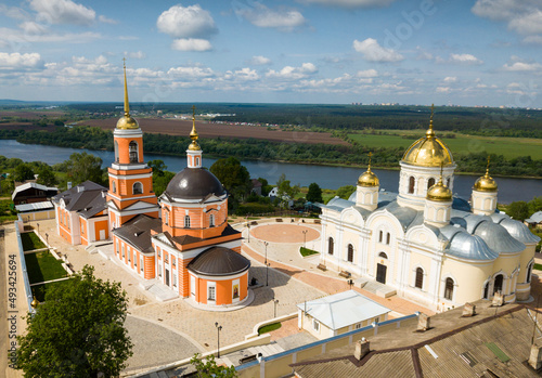 Scenic summer landscape overlooking courtyard of Kashirsky Monastery with golden domes of Transfiguration Cathedral and restored Nikitsky church, Russia