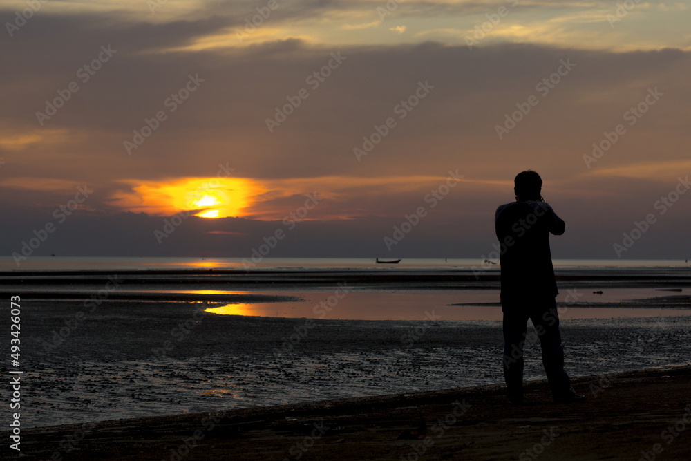 Photographer Silhouette is taking a sunset at the beach Photographer Silhouette is taking a sunset at the beach