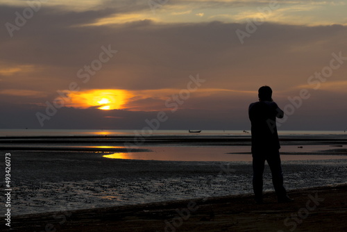 Photographer Silhouette is taking a sunset at the beach © K.Pornsatid