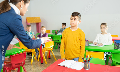 Obraz na plátně Upset boy listening reprimanding of strict female teacher during lesson in prima