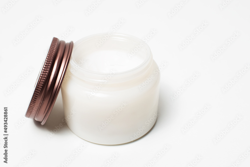 Close-up of opened jar of cosmetic cream near cap, on white background. Close-up of opened jar of cosmetic cream near cap, on white background.