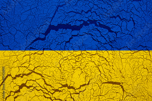 Textured photo of the flag of Ukraine. Background of cracked wall.