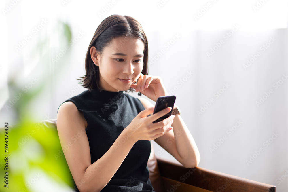 リビングでスマートフォンをする女性