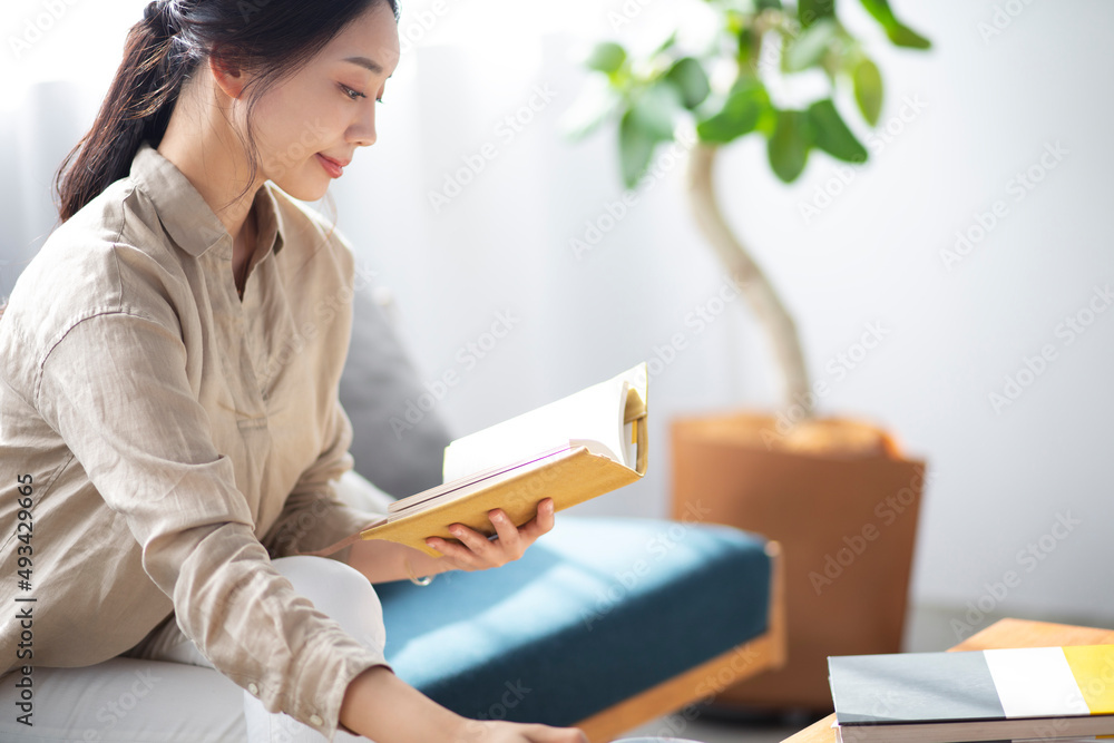 ソファーで読書をする女性