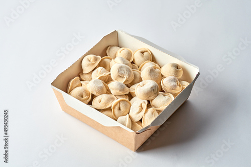 Frozen dumplings in cardboard on a gray background