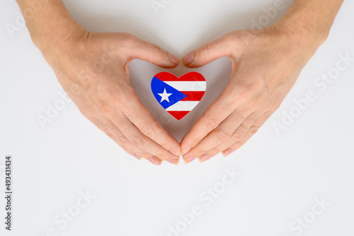 The national flag of Puerto Rico in female hands. The concept of patriotism  respect and solidarity with the citizens of Puerto Rico.