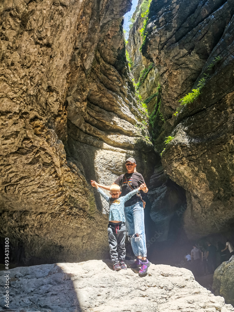 A girl with a child in a canyon in a mountain gorge on the way to the Saltinsky waterfall. Russia Dagestan June 2021.