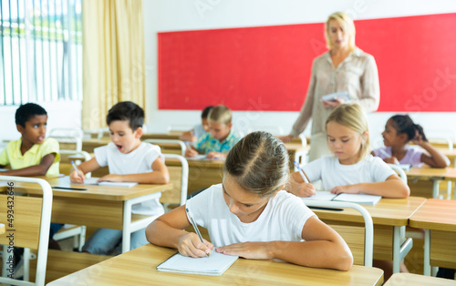 School children writing test, smart young people studying at primary school