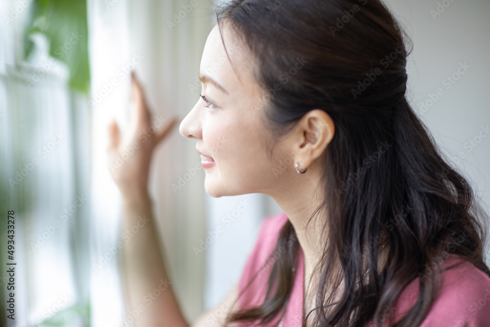 窓の外を見る女性 窓の外を見る女性