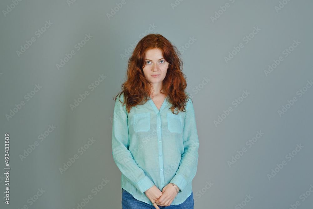 Business portrait of beautiful young woman with red curly hair and blue eyes against colorful background. Lifestyle. Business portrait of beautiful young woman with red curly hair and blue eyes against colorful background. Lifestyle.