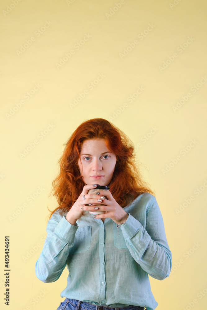 Business portrait of beautiful happy young woman with red curly hair and blue eyes against colorful, gray background. Lifestyle. Business portrait of beautiful happy young woman with red curly hair and blue eyes against colorful, gray background. Lifestyle.