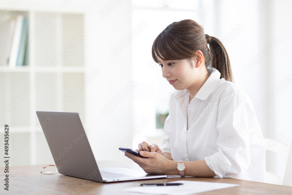 パソコンに向かって座る女性 パソコンに向かって座る女性