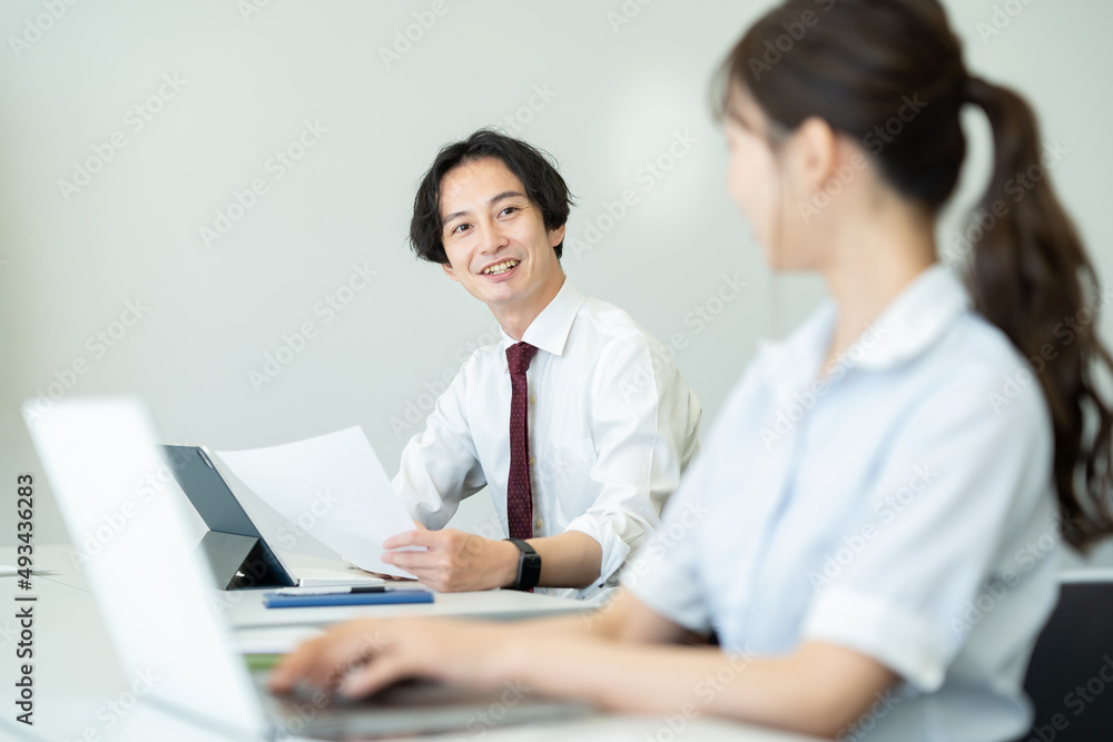 話しながら仕事を進めるビジネスパーソンたち