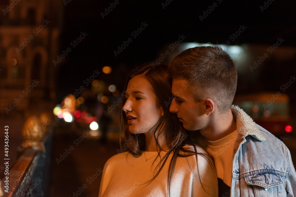 Beautiful young couple stands on the street at night. Romantic date. Beautiful young couple stands on the street at night. Romantic date.