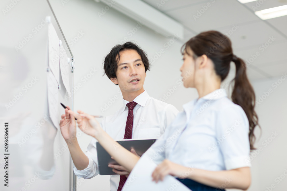 ホワイトボードを使って打ち合わせをするビジネスパーソンたち ホワイトボードを使って打ち合わせをするビジネスパーソンたち