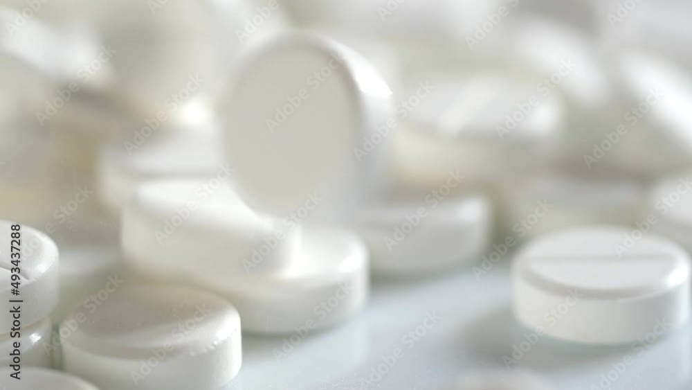 The medicine concept. white medical pills rotating closeup. Pills and drugs. Pharmaceutical Industry. drugs on the production line. moving background. close-up. view from above.super slow motion The medicine concept. white medical pills rotating closeup. Pills and drugs. Pharmaceutical Industry. drugs on the production line. moving background. close-up. view from above.super slow motion