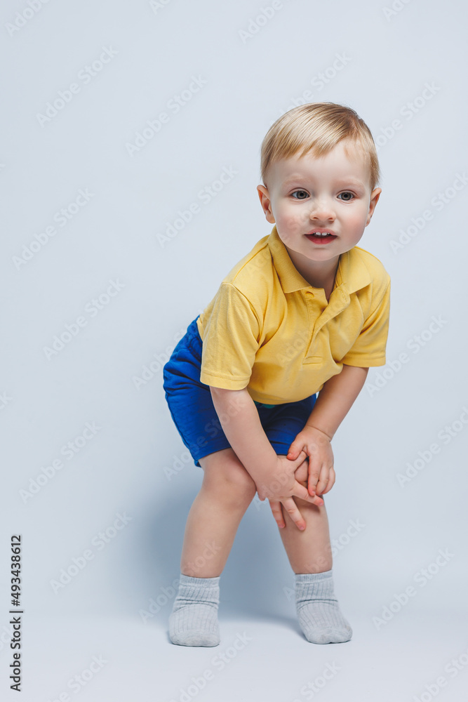 Little boy 3 years old in a yellow T-shirt and blue shorts, a boy in a sports uniform. Little boy 3 years old in a yellow T-shirt and blue shorts, a boy in a sports uniform.