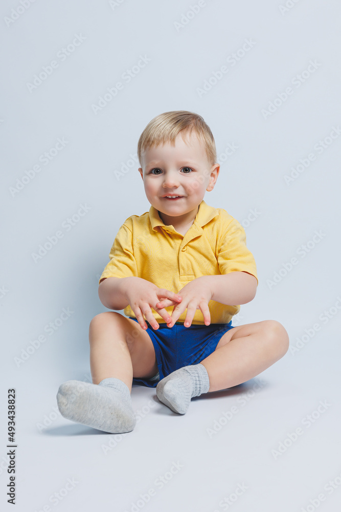 Little boy 3 years old in a yellow T-shirt and blue shorts, a boy in a sports uniform. Little boy 3 years old in a yellow T-shirt and blue shorts, a boy in a sports uniform.