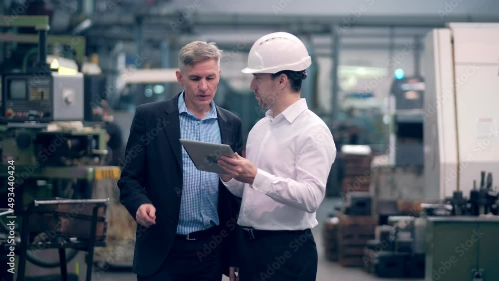 Two engineers at an industrial plant. Two workers control the work at the factory. Manufacture of cutting tools. Drill manufacturing plant. Two engineers at an industrial plant. Two workers control the work at the factory. Manufacture of cutting tools. Drill manufacturing plant.