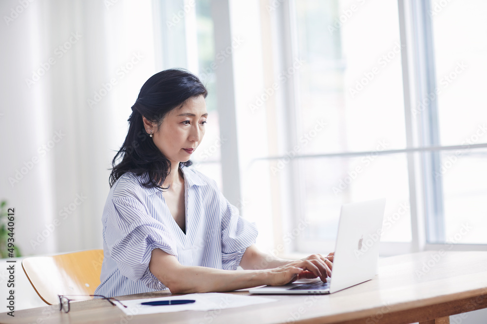 リビングでリモートワークをする女性 リビングでリモートワークをする女性